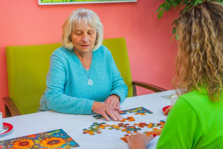 Seniorin puzzelt gemeinsam mit ihrer Betreuungskraft
